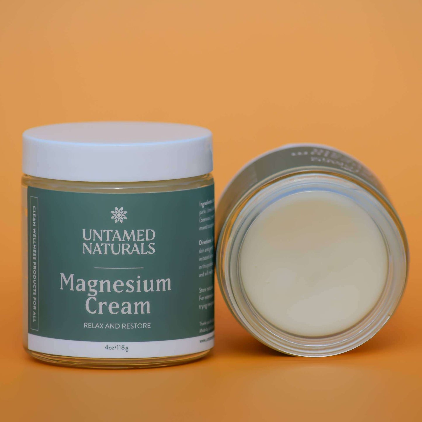 Jar of Untamed Naturals Magnesium Cream on an orange background